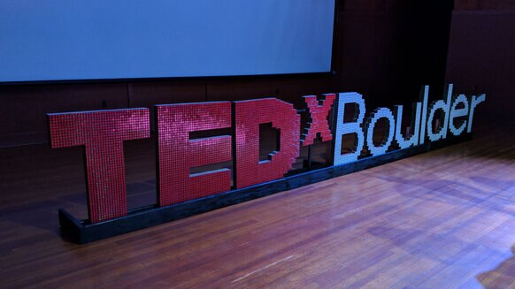 The 2018 TEDxBoulder logo on stage. Yes, it’s made out of Rubik’s cubes, designed and built by speaker Dan Van der Vieren. Credit: Phil Plait