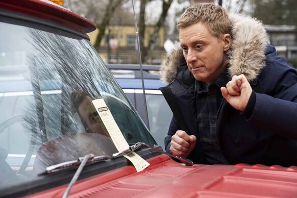 Harry Vanderspeigle looks at a ticket on a windshield in Resident Alien Episode 302.