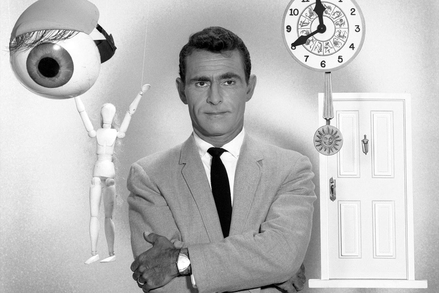 Rod Serling stands while an eye, a figurine, clock, and door float around him.