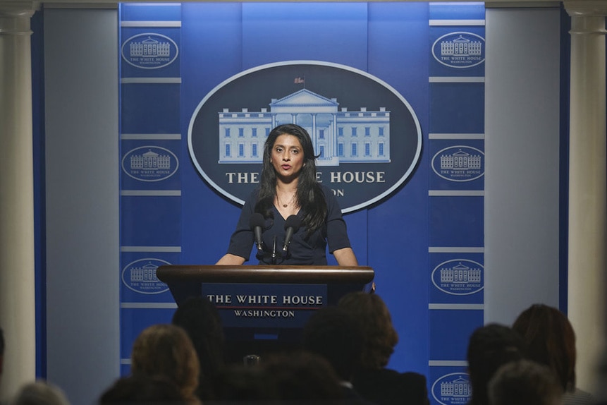 Melanie Spiegel (Ayesha Mansur Gonsalves) delivers a speech in front of a White House press conference backdrop in Chucky 301