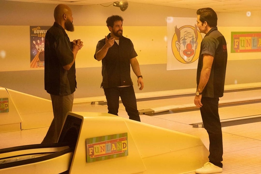 (l-r) August Ripley (Maurice Dean Wint), Father Phil Orley (Adam Korson), and Luke Roman (Tim Rozon) speak at a bowling alley called Funland.