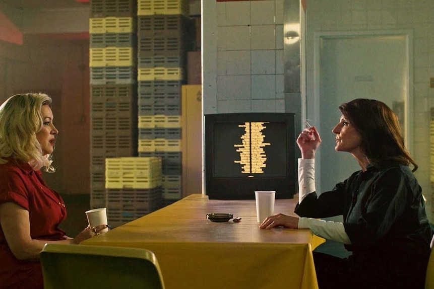 Tiffany (Jennifer Tilly) and Evelyn Elliot (Nia Vardalos) talk over coffee at a table in Chucky 304