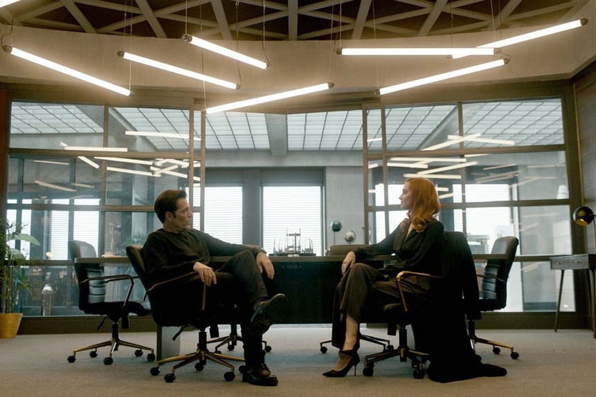 (l-r) Luke Roman (Tim Rozon) and Kay (Tara Yelland) sit together in an office in SurrealEstate 204.