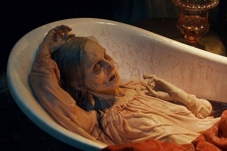 A corpse-like old woman wears a white dress in a bloody bath in SurrealEstate 204.