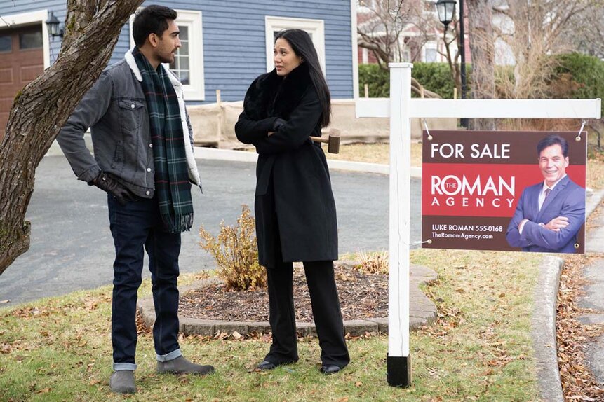 (l-r) Nasir (Daniel Malik) and Lomax (Elena Juatco) stand near a Roman Agency "For Sale" sign on SurrealEstate 209.