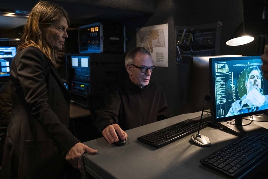 General Eleanor Wright and Mr. Hogan look at a computer on Resident Alien Episode 308.