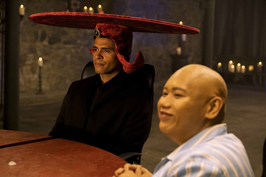 Maurice Miller wears an elaborate hat next to Reginald Andres in Reginald the Vampire Episode 202.