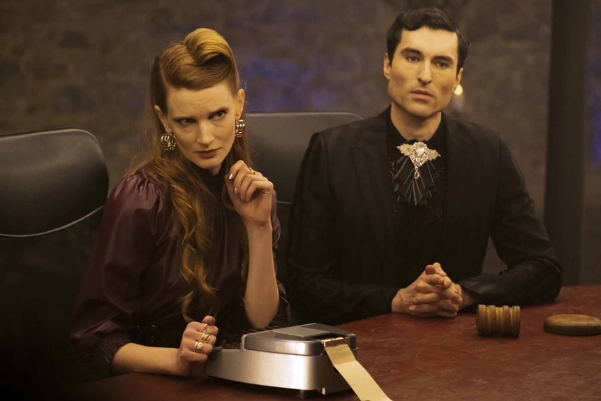 Penelope (Georgia Waters) and LeBron (Sean Yves Lessard) wear all black at a table in Reginald the Vampire Episode 202.