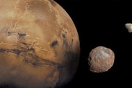 Mars, alongside its two moons, Phobos and Deimos.