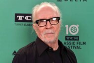 John Carpenter poses for a photo with black glasses on.