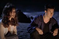Julie James (Jennifer Love Hewitt) and Ray Bronson (Freddie Prinze Jr.) are illuminated by a fire as they sit on a beach in I Know What You Did Last Summer (1997).