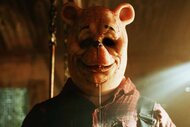 A bloody Winnie the Pooh with sunken eyes and a flannel stares in Winnie the Pooh: Blood and Honey (2023)