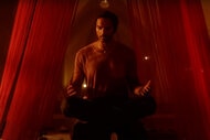 Penny Adiyodi (Arjun Gupta) sits in a meditative state surrounded by red curtains in The Magicians Season 1.