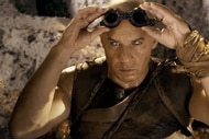 Riddick (Vin Diesel) adjust goggles on his forehead as his eyes glow white in Riddick (2013).