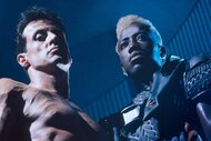 John Spartan (Sylvester Stallone) is shirtless while blonde Simon Phoenix (Wesley Snipes) wear armor in Demolition Man (1993).