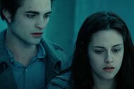 Edward Cullen (Robert Pattinson) stands behind Bella Swan (Kristen Stewart) in Twilight (2008).