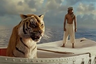 Pi Patel (Suraj Sharma) floats on a boat with a tiger in Life of Pi (2012).