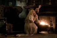 Edith Cushing (Mia Wasikowska) fearfully grips onto Thomas Sharpe (Tom Hiddleston) in front of a fireplace in Crimson Peak (2015).