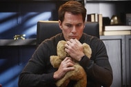 Luke Roman (Tim Rozon) holding a stuffed animal and looking concerned