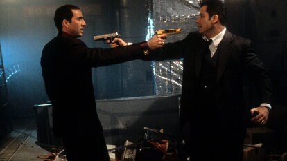 Nicolas Cage and John Travolta aiming guns at each other in a scene from the film 'Face/Off' (1997)