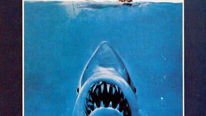 The Jaws (1975) Poster featuring a shark encroaching upon a swimmer.