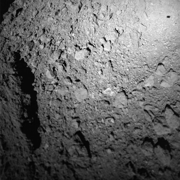 An image from the MASCOT lander as it headed down to the asteroid Ryugu. Note the shadow of the lander to the upper right. Credit: JAXA/DLR/CNES
