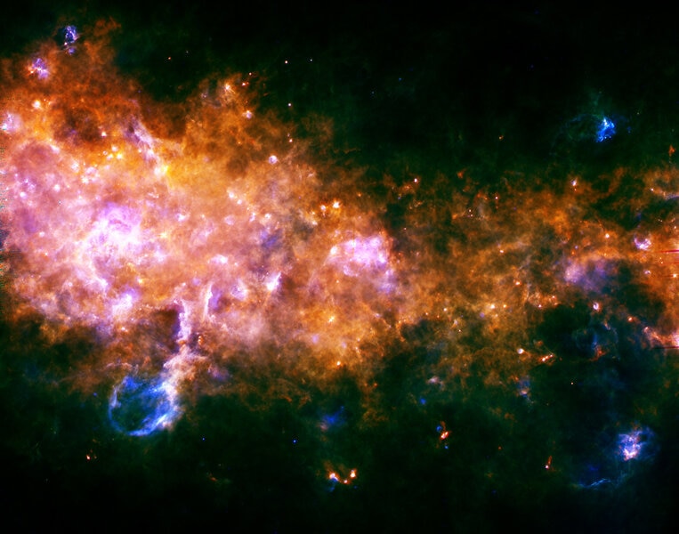 Far-infrared Herschel observatory image of cold dust and gas in the Milky Way. Note the blowout at the lower left. Credit: ESA/Hi-GAL Consortium