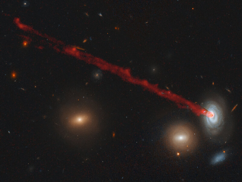 The galaxy D100 has a vast streamer of gas being blown out of it as it rams the thin gas between galaxies in the Coma Cluster. This image combines data from the Subaru observatory (red) with a Hubble image. 