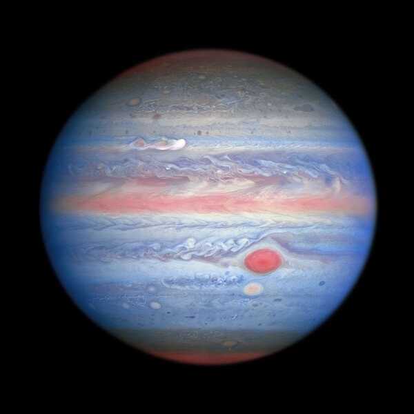 Jupiter in ultraviolet, visible, and infrared light, a multispectral image that helps astronomers understand the atmosphere of the giant planet. Note the new elongated storm to the upper left.