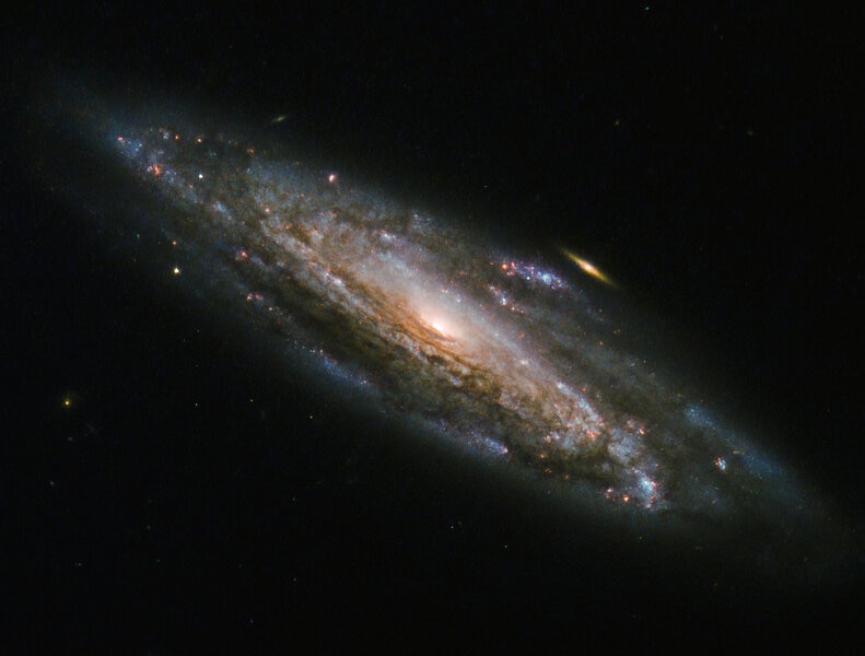 NGC 5559 and a little friend, imaged by Hubble Space Telescope. Credit: ESA/Hubble &amp; NASA