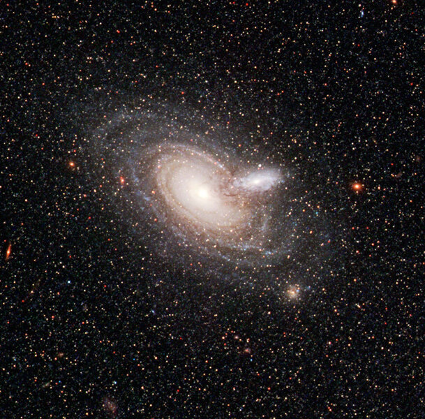 Two overlapping galaxies, some 800 million light years away, were captured by Hubble accidentally while viewing a much closer galaxy (NGC 253, off screen to the right). 