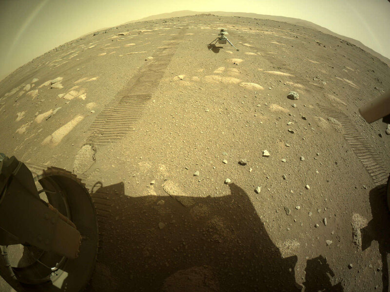 An astonishing image of the Ingenuity drone copter sitting on Mars, seen in the distance with the rover tracks leading away from it. Credit: NASA/JPL-Caltech