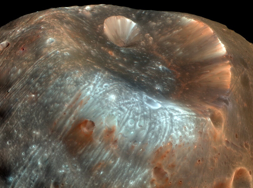 A color-enhanced image of the crater Stickney and some of the grooves covering Phobos, a moon of Mars. Credit: NASA/JPL-Caltech/University of Arizona