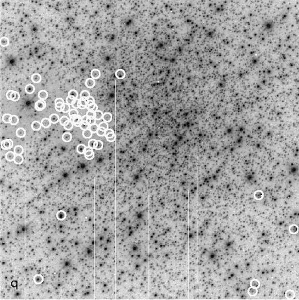 A small clutch of red stars (indicated by circles) can be found on one side of the cluster NGC 1898, corresponding to an area of lower density of stars overall, indicating a patch of dust obscuring it. The vertical lines are image artifacts and aren’t rea