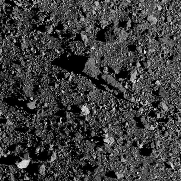 A long rock (center), possibly the remnants of a shattered, even bigger boulder, lies on the surface of the asteroid Bennu. It’s nearly 19 meters long, almost the length of  tennis court. Credit: NASA/Goddard/University of Arizona