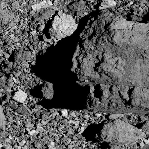 The largest boulder on Bennu, called BenBen, casts a shadow across an assortment of rocks on the surface. Note all the different reflectivities of the rocks; some are quite dark while others reflect more light. Credit: NASA/Goddard/University of Arizona