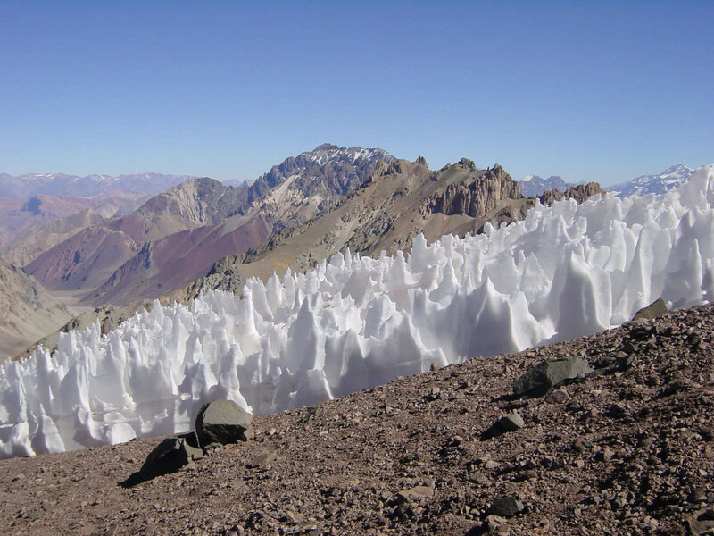 A field of penitentes, spiky ice towers formed as ice sublimates into a gas, in Argentina (Earth). Credit: Sastognuti / Wikimedia Commons