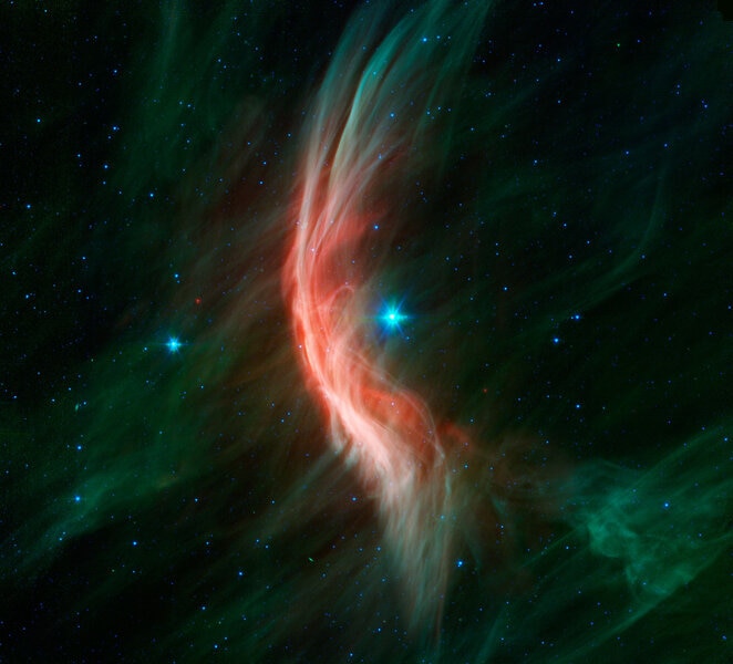 The massive star Zeta Ophiuchi plows through space, ramming a huge sheet of dust into an arc shape as its wind pushes against it. Credit: NASA/JPL-Caltech