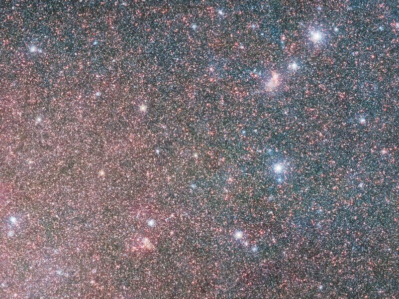 A small section of the huge VISTA infrared image of the Large Magellanic Cloud, showing where the redder bar and bluer spiral border. This is shown at less than half the full resolution. Credit: ESO/VMC Survey