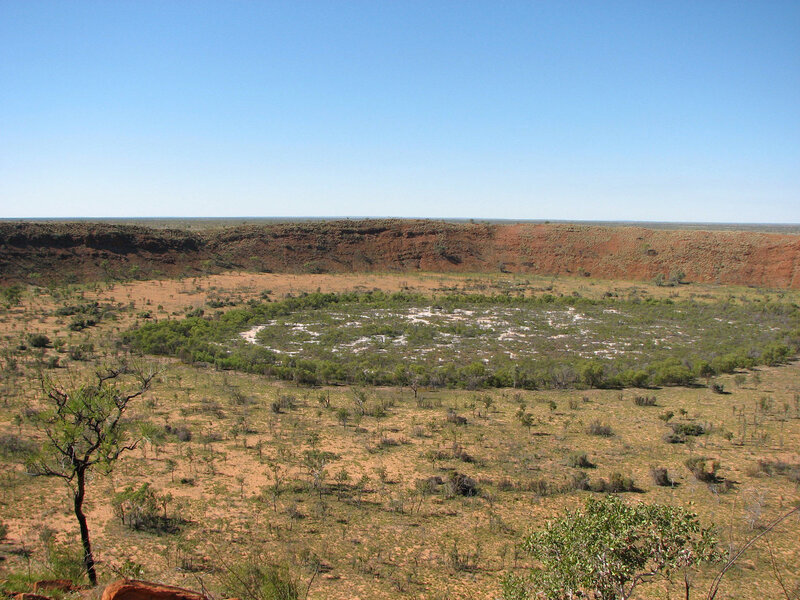 The interior of Wolfe Creek crater in Australia (the wall of rock in the background is the rim). Credit: Harclade