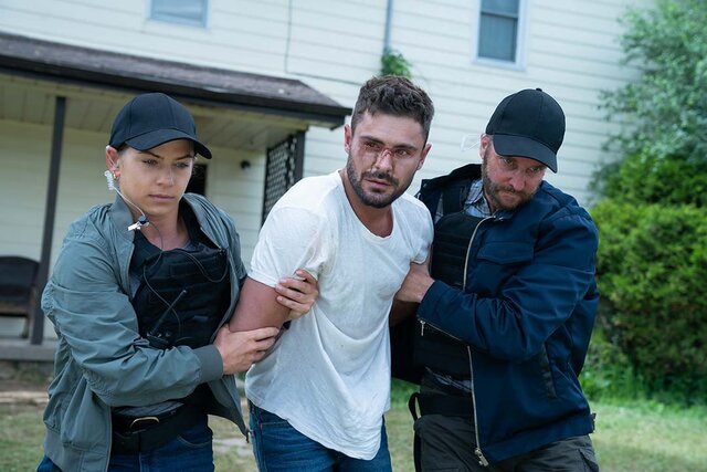 A bruised Zac Efron is escorted away by agents in Firestarter (2022)