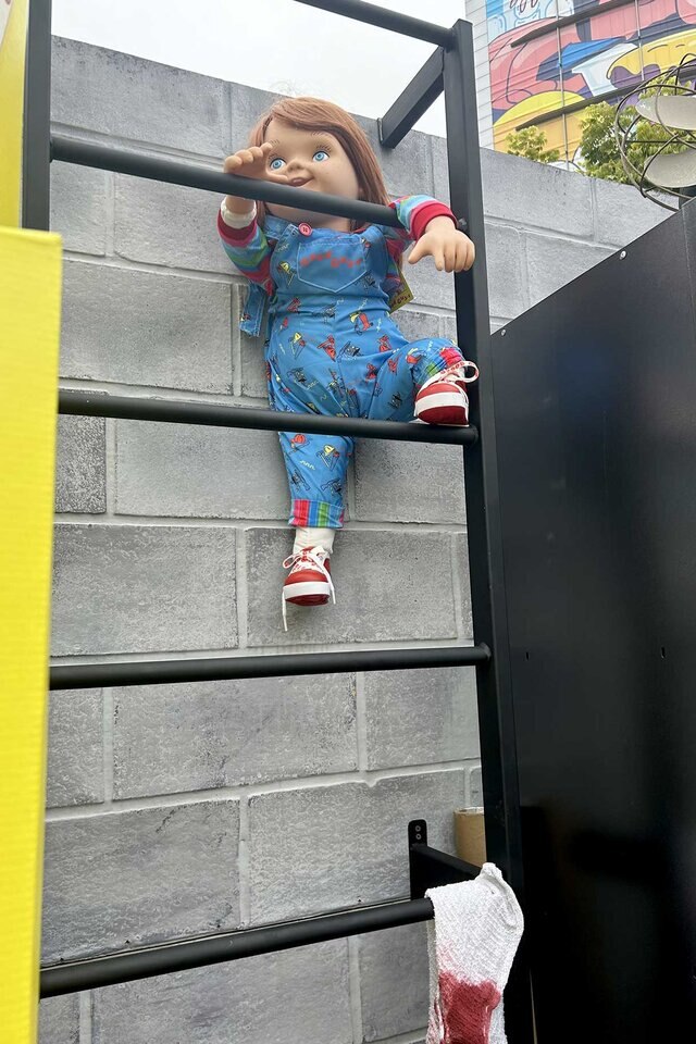 Chucky climbs a ladder at the Chucky Activation at San Diego Comic-Con 2023