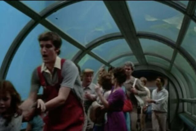 People panic in a glass aquarium hallway in Jaws 3D (1983)