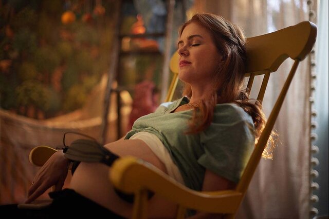 Mary (Isla Fisher) holds headphones to her pregnant belly in Wolf Like Me Season 2