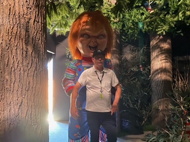 A man poses with Chucky at Universal Studios Hollywood Halloween Horror Nights 2023