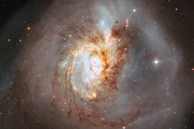 A closer look at the center of NGC 3256 reveals the chaos there, struggling to recover order. Dark dust clouds and bright stars may yet retain their overall spiral distribution.  Credit: ESA/Hubble, NASA