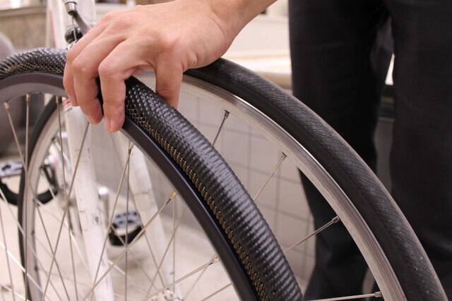 A SMART METL bicycle tire shown alongside a conventional rubber tire