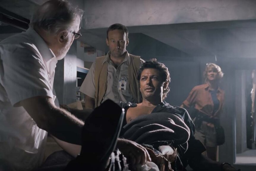 Jeff Goldblum's injury is tended to as Bob Peck and Laura Dern look on in Jurassic Park (1993)