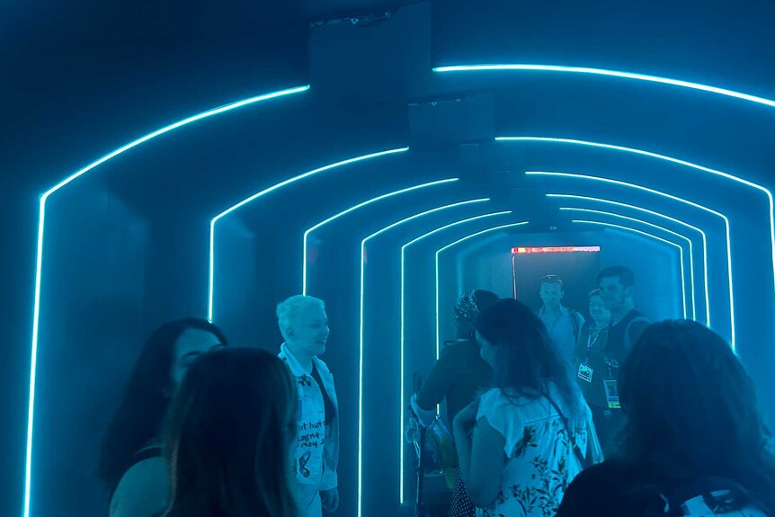 Fans in a dark hallway with blue neon lights during the Quantum Leap Activation at SDCC 2023