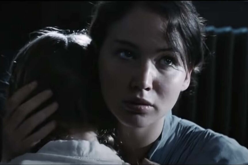 Katniss (Jennifer Lawrence) embraces Prim (Willow Shields) in The Hunger Games (2012)